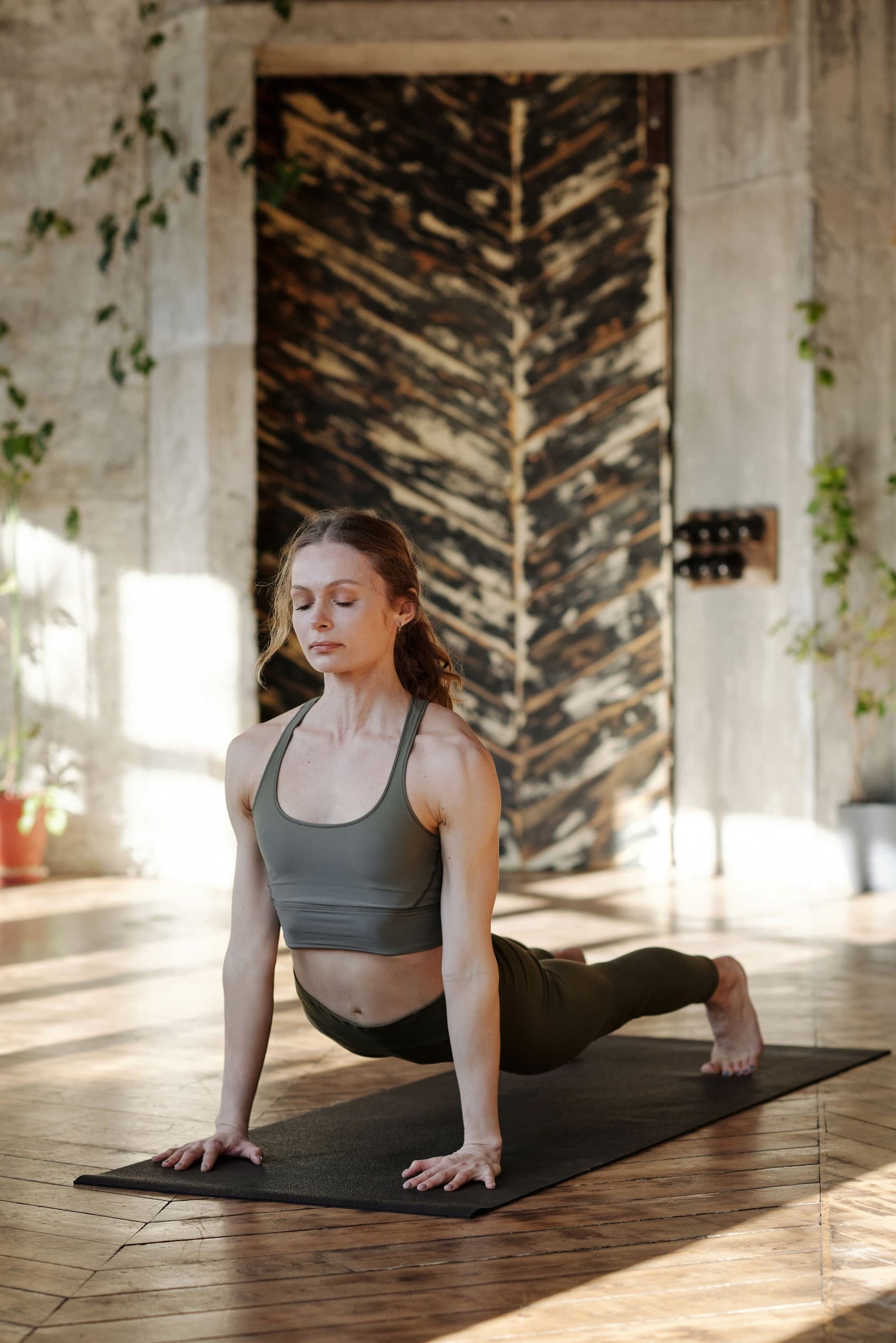 Mujer practicando yoga en un estudio boutique con luz cálida